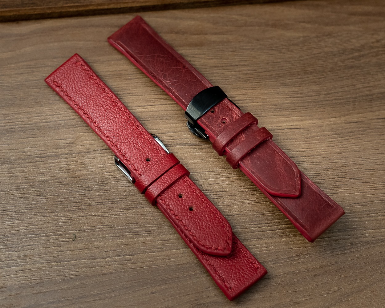 Duas pulseiras de couro vermelho com acabamentos e fivelas diferentes